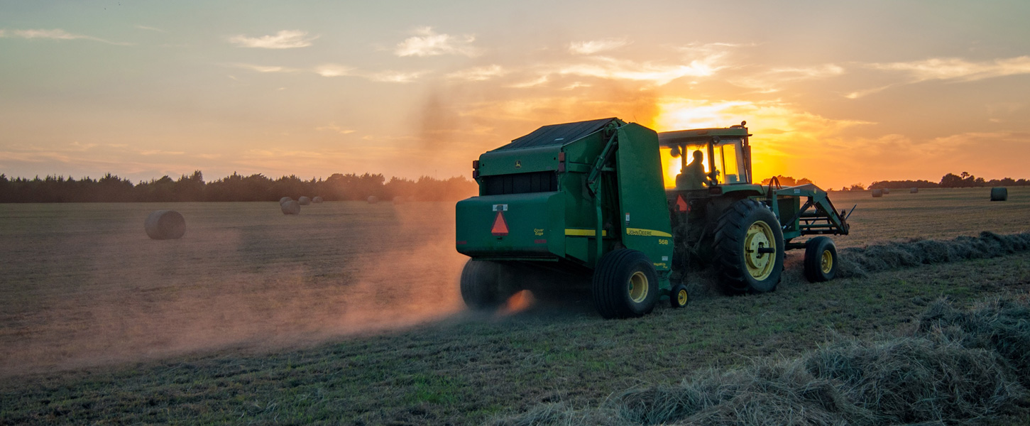 Tractor in field at sunset