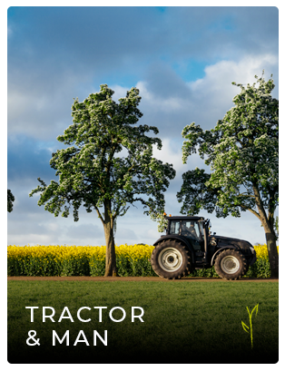 Tractor driving along a hedge in a field
